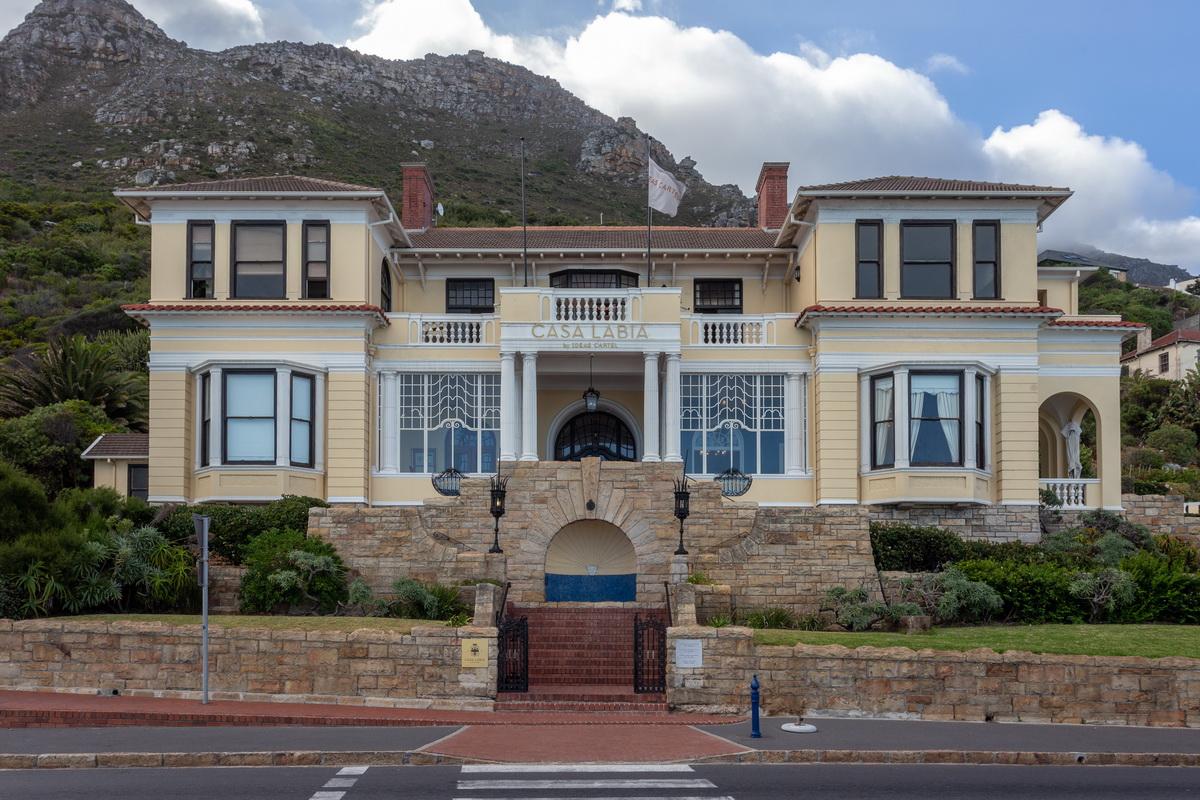 Cream Italianate façade of Casa Labia on Muizenberg Main Road with mountain behind