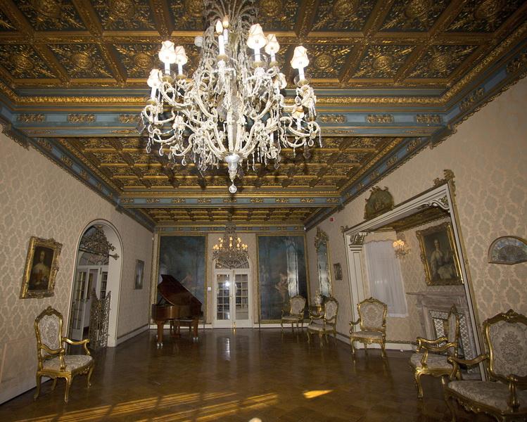 Gilded music room with chandelier, coffered ceiling and painted panels