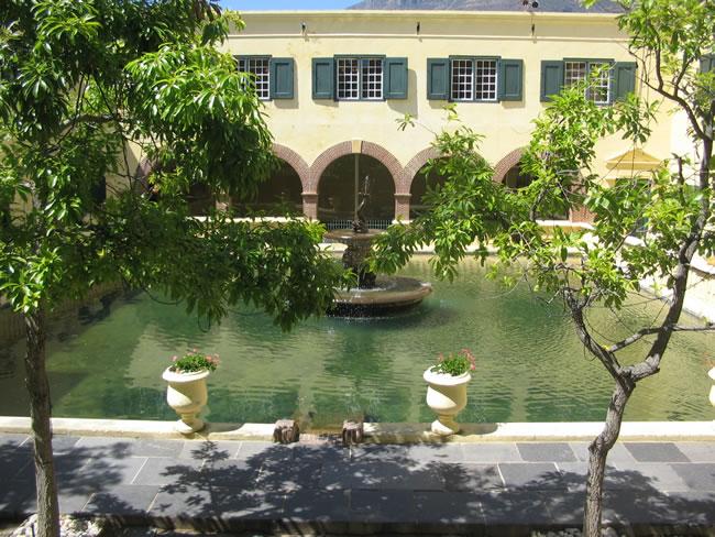Orange trees and planted urns beside the courtyard pool under the arcade