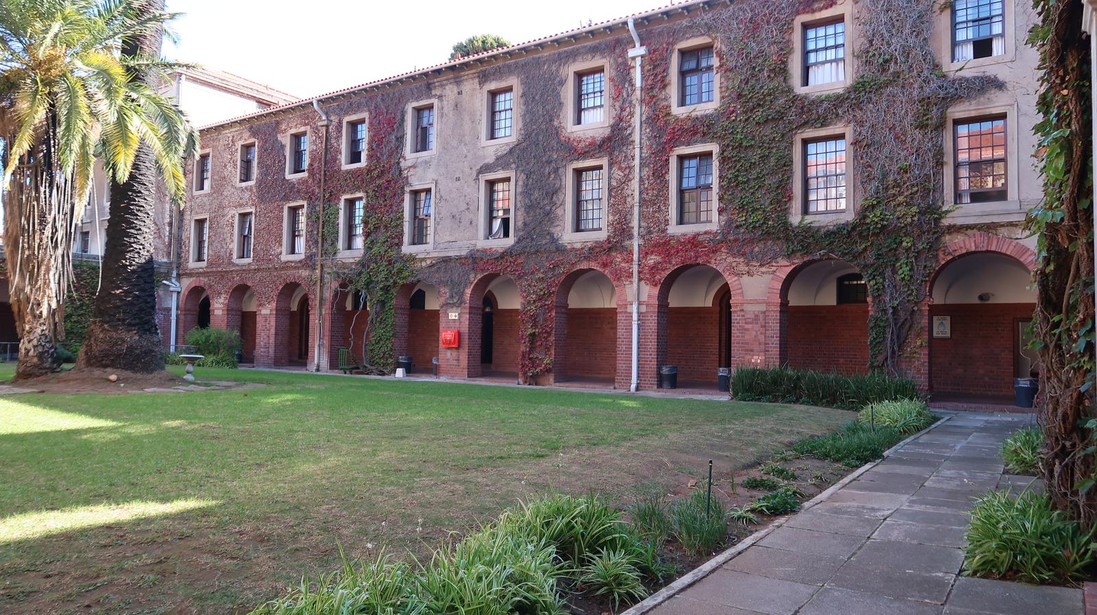 Smuts Hall courtyard lawn enclosed by arcaded red-brick wings