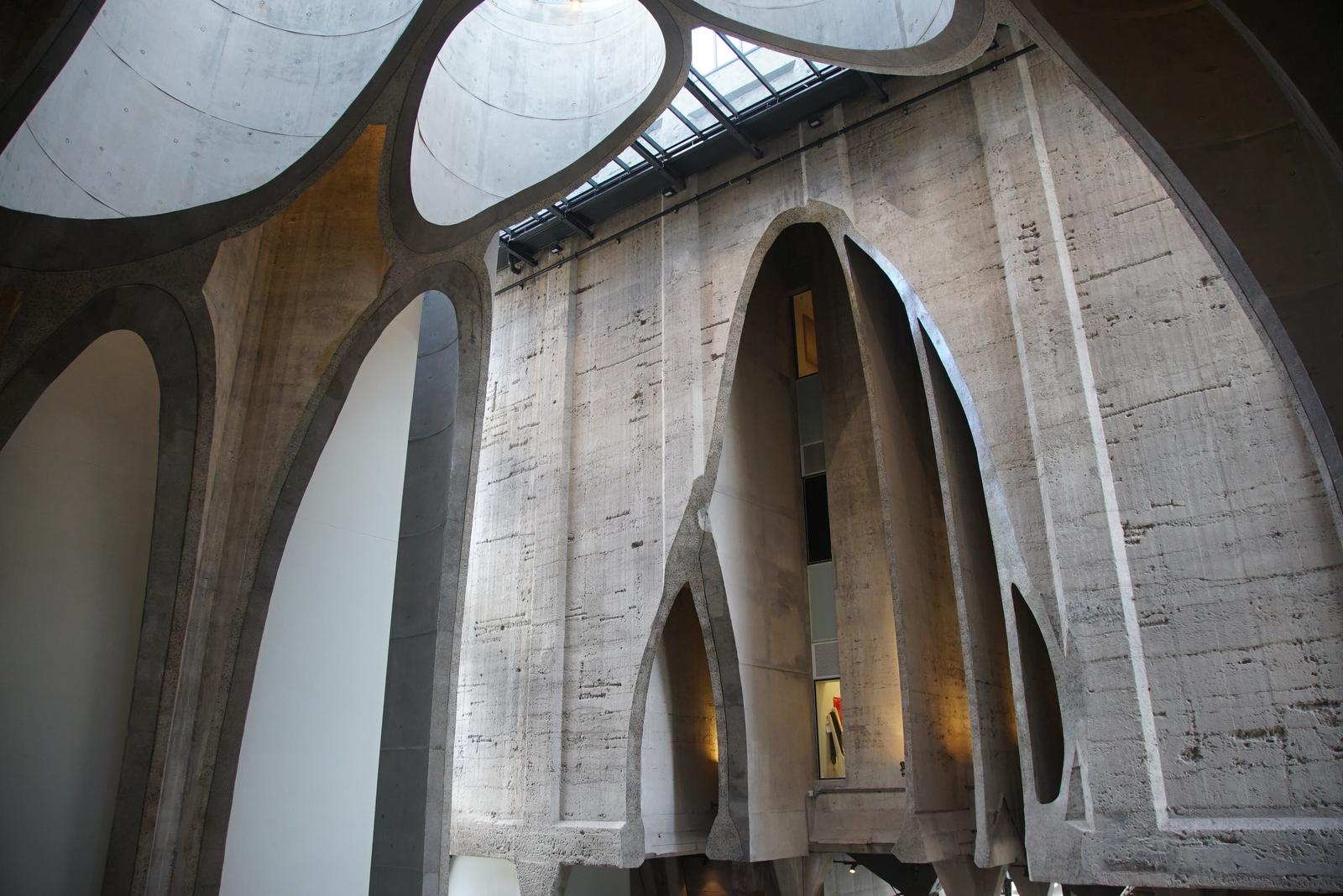 Curved concrete arches carved from silo cylinders with gallery windows behind