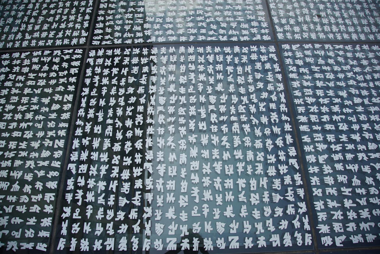 Pillowed glazing panels of the silo façade in close-up, geometric pattern filling the frame